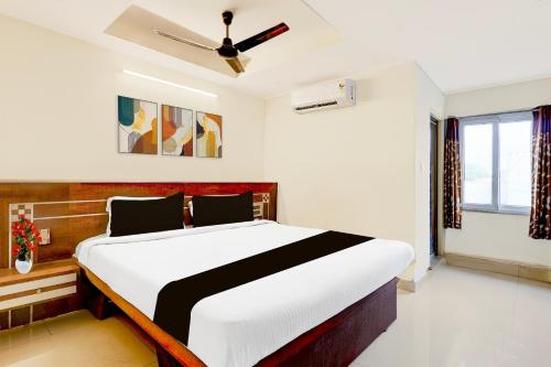 Un dormitorio con una cama grande con ventilador de techo. en Super Townhouse Sankaramatam Road Near Diamond Park, en Visakhapatnam