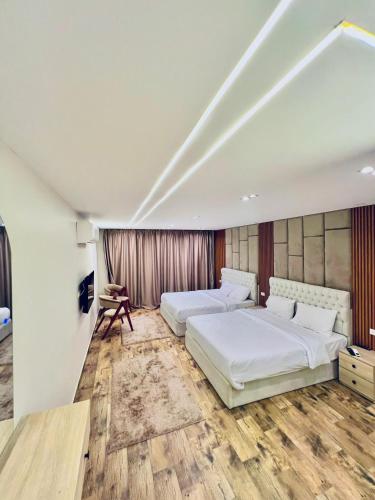 two beds in a room with wooden floors at Atta pyramid view inn in Cairo