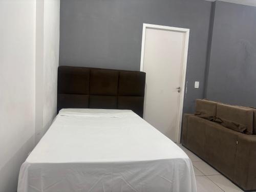 a bedroom with a bed and a couch in a room at park style aconchego in Brasilia