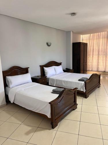 two beds sitting in a room with at Hôtel la marina in Al Hoceïma