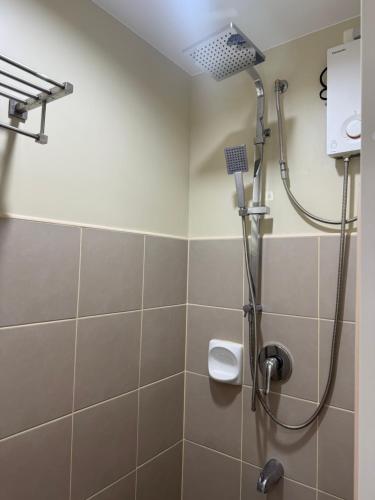 a bathroom with a shower with a shower head at Amayara Nest Hospitality 2BR Condo with Netflix in Cagayan de Oro