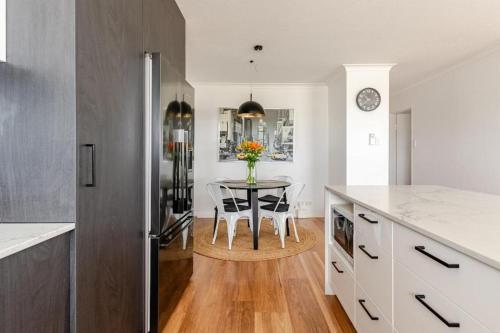 a kitchen with a table with a vase of flowers at City View Serviced Apartments in Brisbane