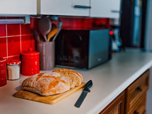a loaf of bread on a cutting board on a kitchen counter at 2 Bed in Machynlleth 93079 in Cemmaes