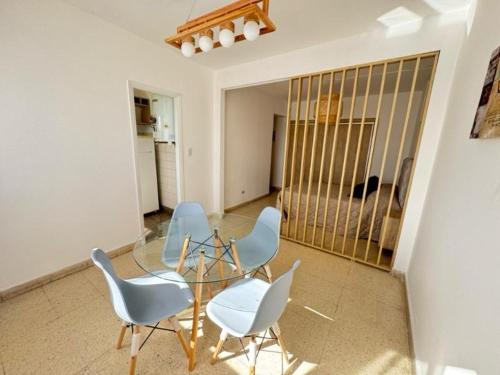 a dining room with chairs and a glass table at Depto zona centro MDP in Mar del Plata