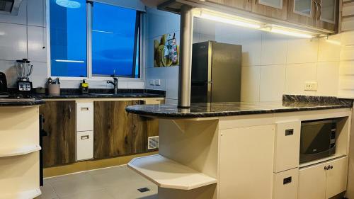 a large kitchen with a counter and a refrigerator at Movie Escape in La Paz