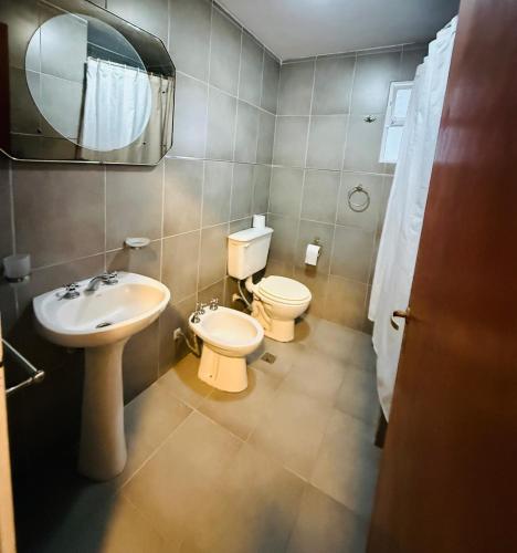 a bathroom with a sink and a toilet and a mirror at Departamento luminoso Bulnes 3 dormitorios in San Miguel de Tucumán