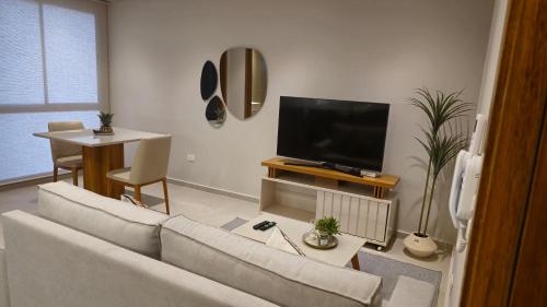 a living room with a couch and a flat screen tv at Departamento a estrenar en Mburucuya in Asuncion