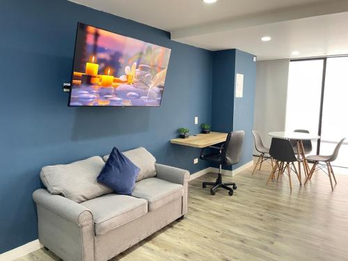 a living room with a couch and a table at Laureles Loft con terraza privada cerca Parques Del Río in Medellín