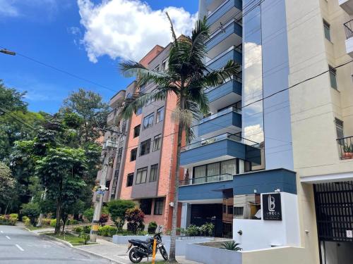 a motorcycle parked in front of a tall building at Laureles Loft con terraza privada cerca Parques Del Río in Medellín
