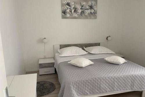 a bedroom with a bed with two pillows on it at Apartments with parking space Kali, Ugljan - 24022 in Kali