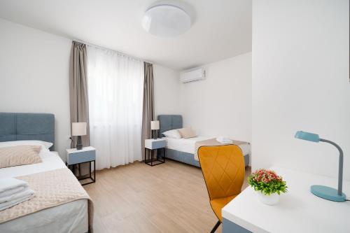 a hotel room with two beds and a desk with a table at Holiday house with a parking space Rogotin, Neretva Delta - Usce Neretve - 24802 in Rogotin