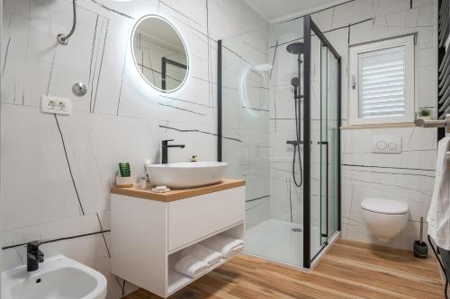a white bathroom with a sink and a shower at Holiday house with a parking space Rogotin, Neretva Delta - Usce Neretve - 24802 in Rogotin