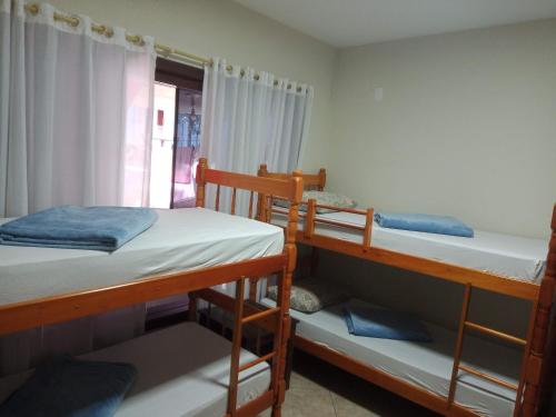 a room with three bunk beds and a window at Blu Hostel in Blumenau