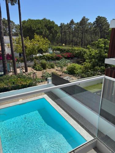 a swimming pool on the balcony of a house at Aroeira Beach Home in Almada