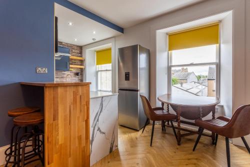 een keuken en eetkamer met een tafel en stoelen bij Centre Meadowside Residence in Edinburgh