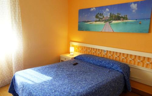 a bedroom with a bed and a painting on the wall at Hostal Isla Playa in Isla