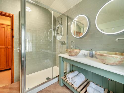 a bathroom with a shower and two sinks and mirrors at Steppe Haugh in Hawes