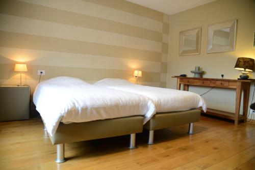a bedroom with a large white bed and a desk at Race & Rooms in Francorchamps