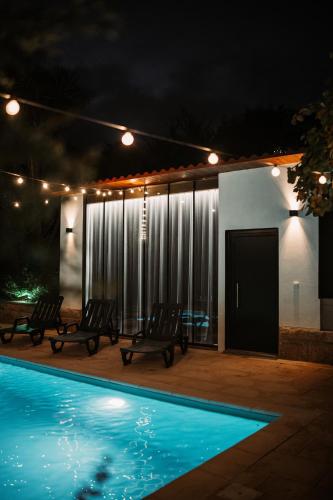 a patio with chairs and a swimming pool at night at Quinta da Quintã AL in São Pedro do Sul