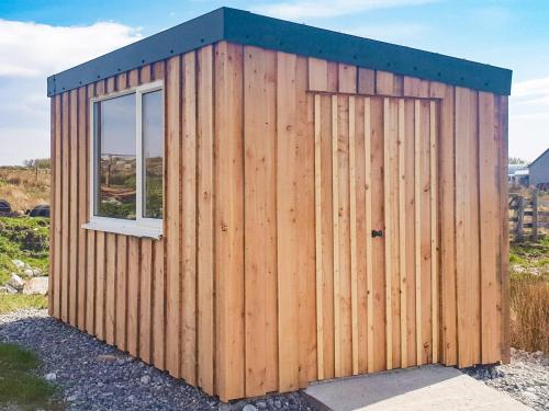 a wooden shed with a window on the side at Seaview in Barvas