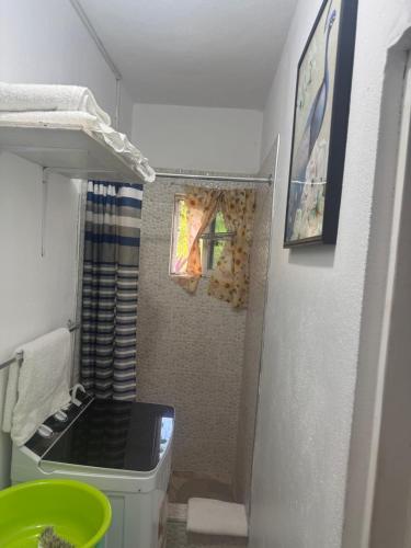 a small bathroom with a toilet and a shower at June’s comfort paradise in Runaway Bay