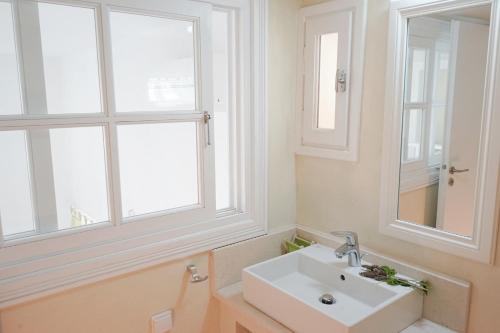 a bathroom with a sink and two windows at Kiki's Houses Vlichos in Hydra