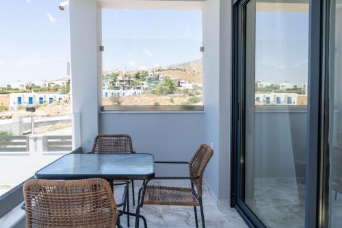 a dining room with a table and chairs and a window at Kalon Gaia NOSTOS in Karistos