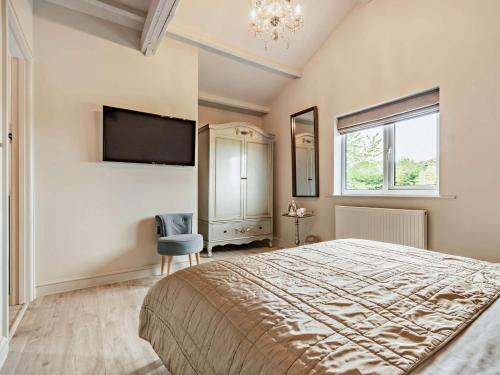 a bedroom with a large bed and a tv on the wall at 3 Bed in Melton Mowbray 61788 in Melton Mowbray