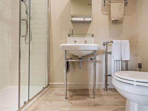 a bathroom with a sink and a toilet and a shower at 3 Bed in Melton Mowbray 61788 in Melton Mowbray