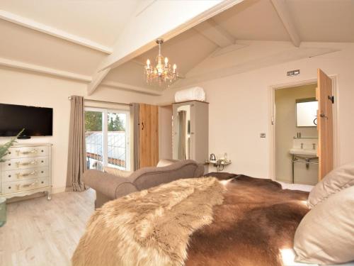 a living room with a large bed and a chandelier at 3 Bed in Melton Mowbray 61788 in Melton Mowbray