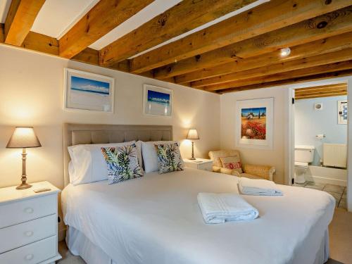 a bedroom with a large white bed and wooden ceilings at 3 Bed in Shaftesbury 95685 in Sedghill