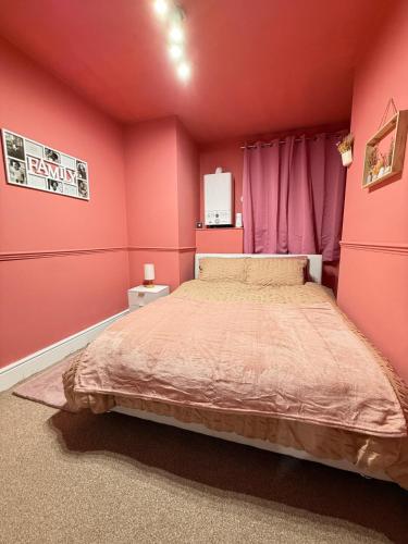 a bedroom with pink walls and a large bed at The Rosy Retreat By Station in Cambridge