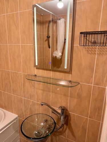 a bathroom with a glass sink and a mirror at Enjoy city living in this one-bedroom flat, complete with a balcony and secure parking in Birmingham city center in Birmingham