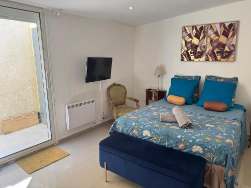 a bedroom with a blue bed and a tv at Charmant T2 à 5 minutes de l'Aéroport d'Orly in Paray-Vieille-Poste