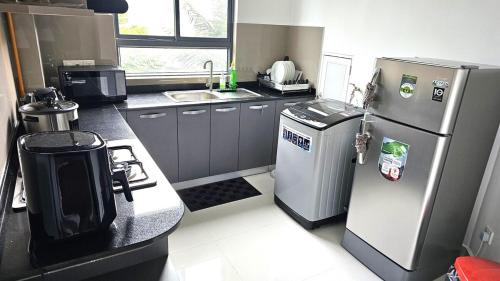 eine kleine Küche mit einem Kühlschrank und einem Herd in der Unterkunft Biyanka's lovely apartment in Sri Jayewardenepura Kotte