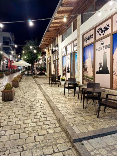an empty street with tables and benches in a building at Rooms Kruja City in Krujë