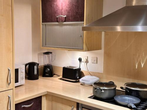 a kitchen with a counter top with pots and pans at Enjoy city living in this one-bedroom flat, complete with a balcony and secure parking in Birmingham city center in Birmingham