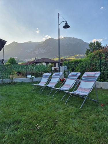 a group of lawn chairs sitting in the grass at Casa Regina 21 - Families & Friends Dolomites in Ponte delle Arche