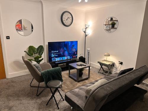 a living room with a couch and a tv at Enjoy city living in this one-bedroom flat, complete with a balcony and secure parking in Birmingham city center in Birmingham