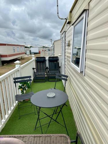 a patio with two chairs and a table on a balcony at Avas Special Place in Ingoldmells