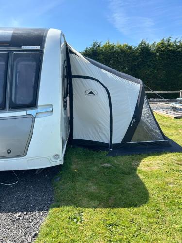 a white trailer with its door open on the grass at Dolafon farm luxury caravan stay in St Asaph