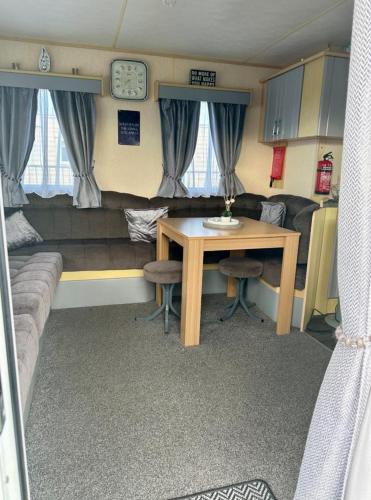 a living room with a table and a couch at Avas Special Place in Ingoldmells