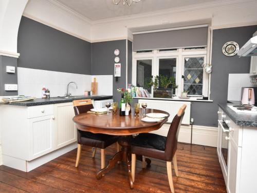 a kitchen with a wooden table and chairs in a kitchen at 1 Bed in Goodwick FB158 in Goodwick