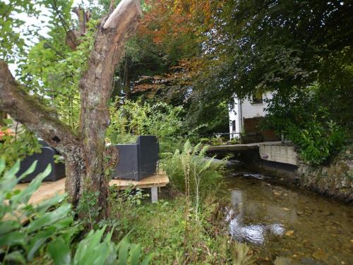 a bench sitting next to a river with a house at 3 Bed in Cenarth 79198 in Felindre
