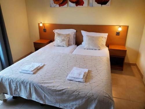 a bedroom with a bed with two towels on it at Spacious villa with garden and pool in Les Forges