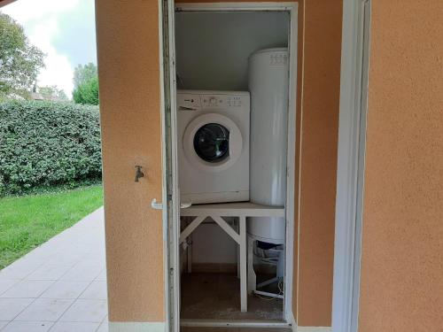a washer and dryer sitting inside of a house at Spacious villa with garden and pool in Les Forges