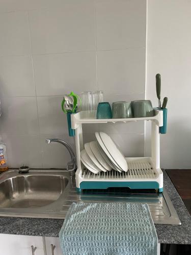 a kitchen sink with a drying rack next to a sink at Coral Whispers in Malindi