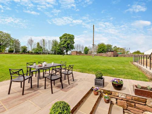 a patio with a table and chairs and a field at 3 Bed in Appleby 94764 in Brampton