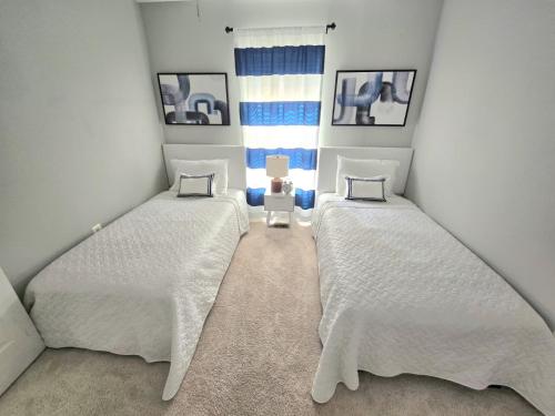 two twin beds in a room with a window at Loudoun Metro Station Home in Ashburn