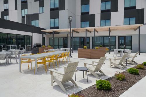 a patio with tables and chairs in front of a building at TownePlace Suites by Marriott Columbus in Columbus